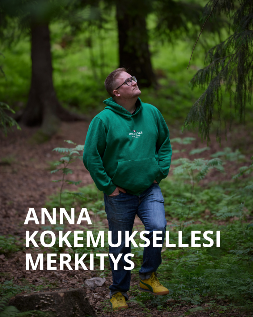 Henkilö kävelee metsässä ja katselee ympärilleen. Teksti päällä: Anna kokemuksellesi merkitys